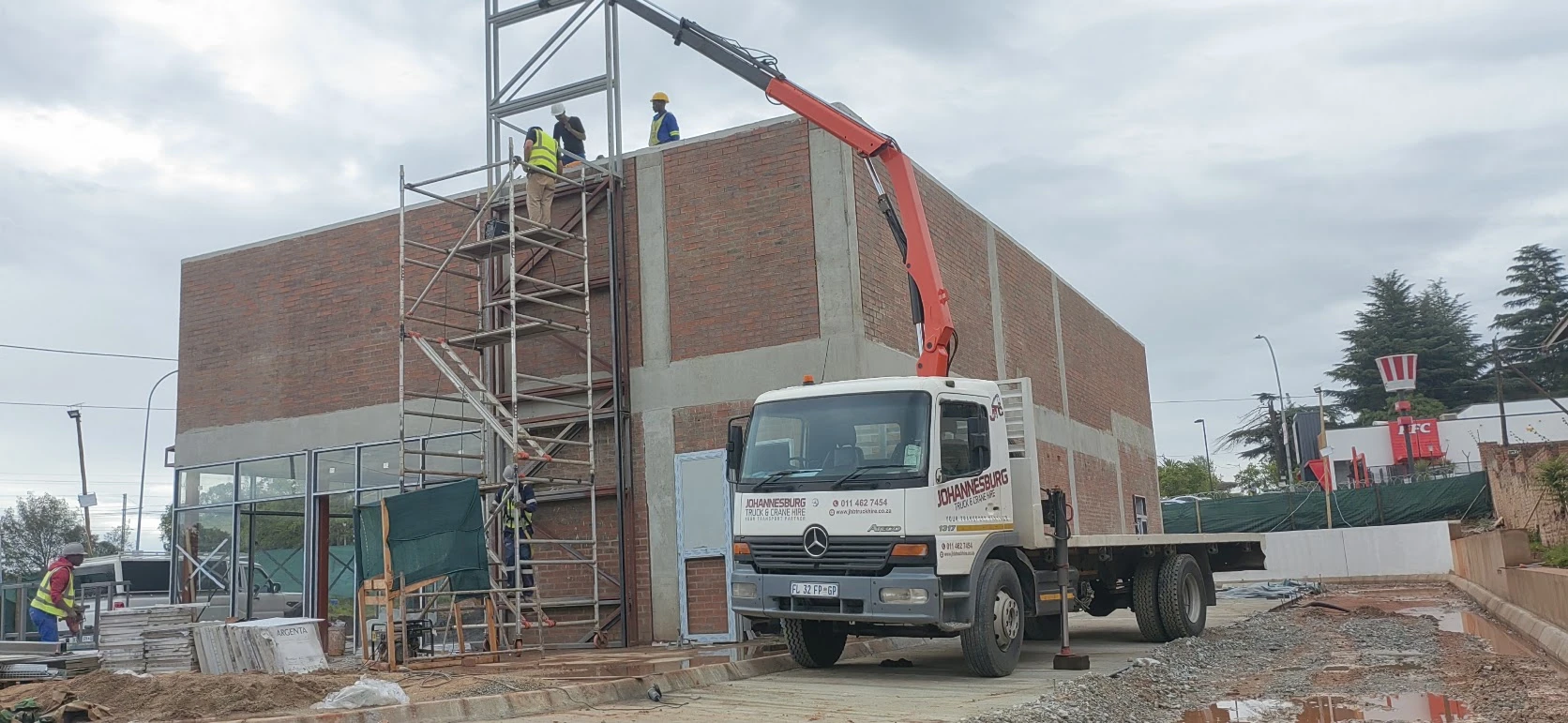 JHB crane truck lifting a steel structure at a construction site
