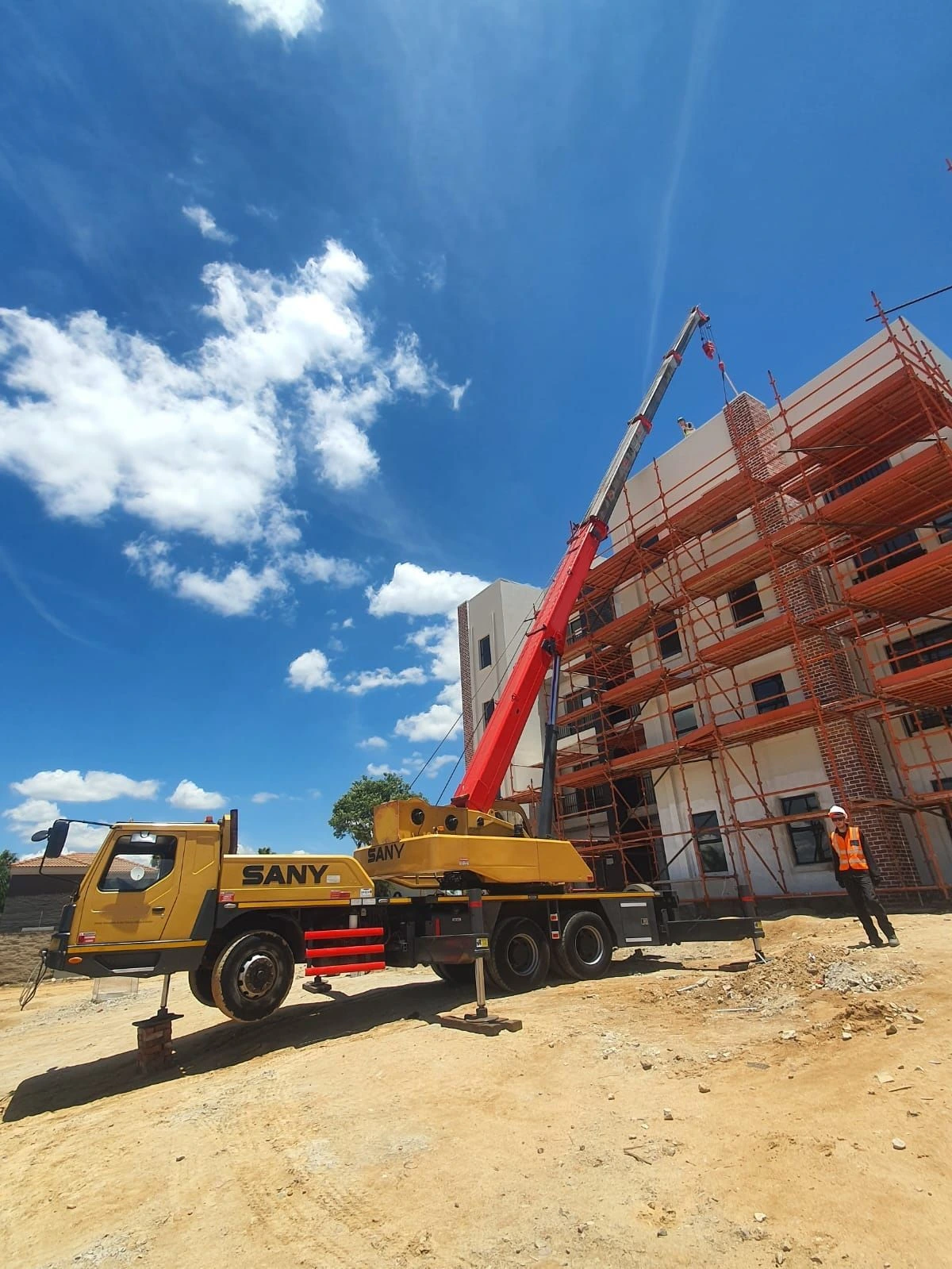 SANY mobile crane working beside a building under construction