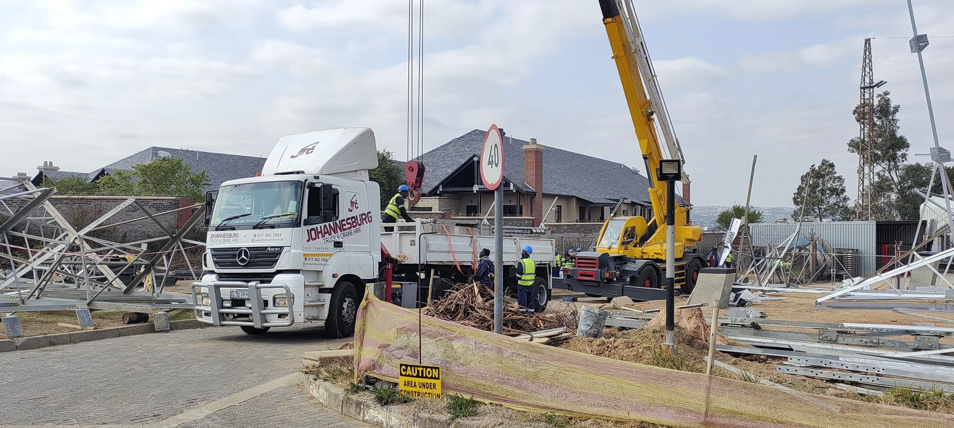 JHB truck, mobile crane and crew working together on site