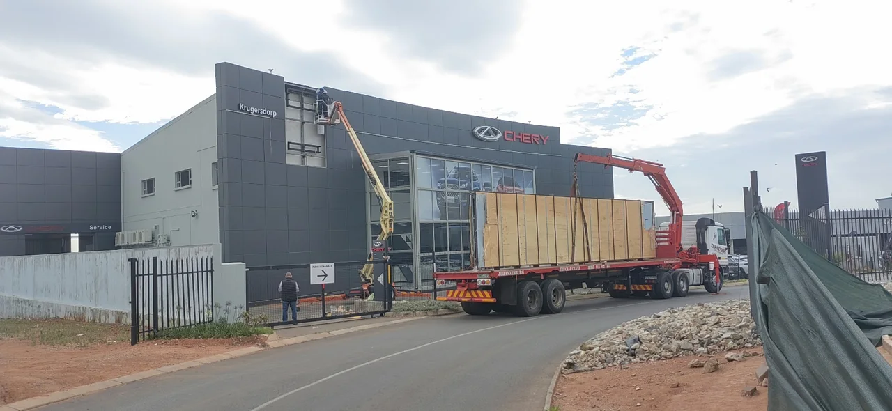 Crated load on a branded JHB crane truck and trailer