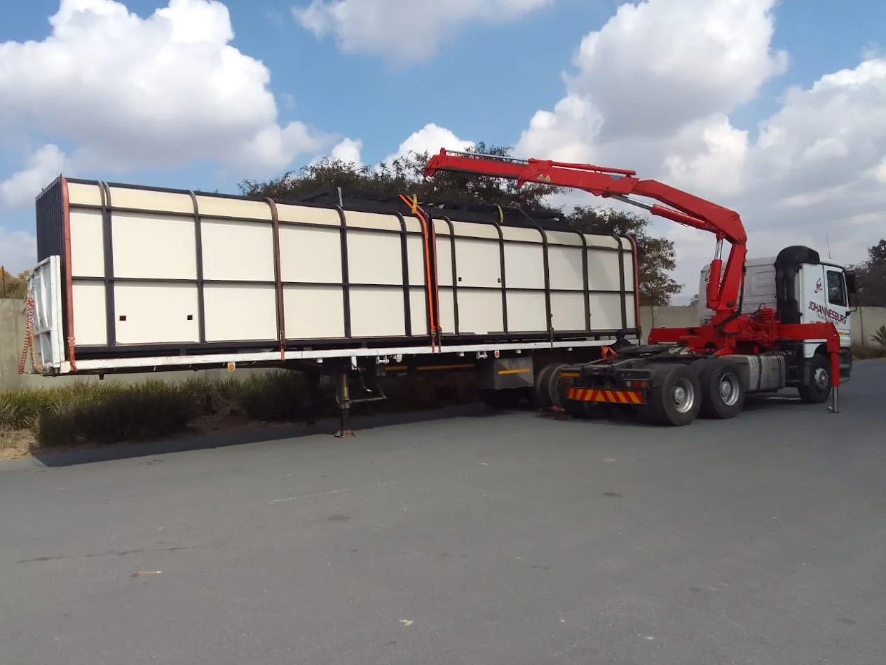 Large equipment secured on a JHB truck-mounted crane trailer