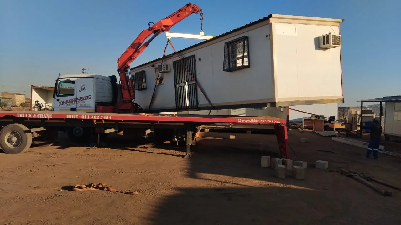 JHB crane truck lifting a park home with a lifting beam and slings