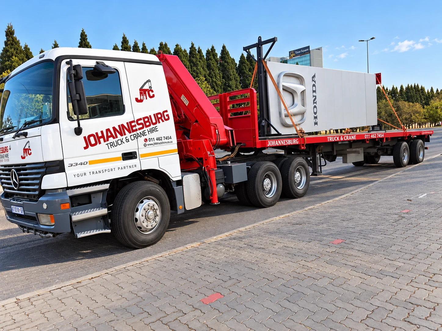 Enhanced JTC crane truck carrying white industrial equipment