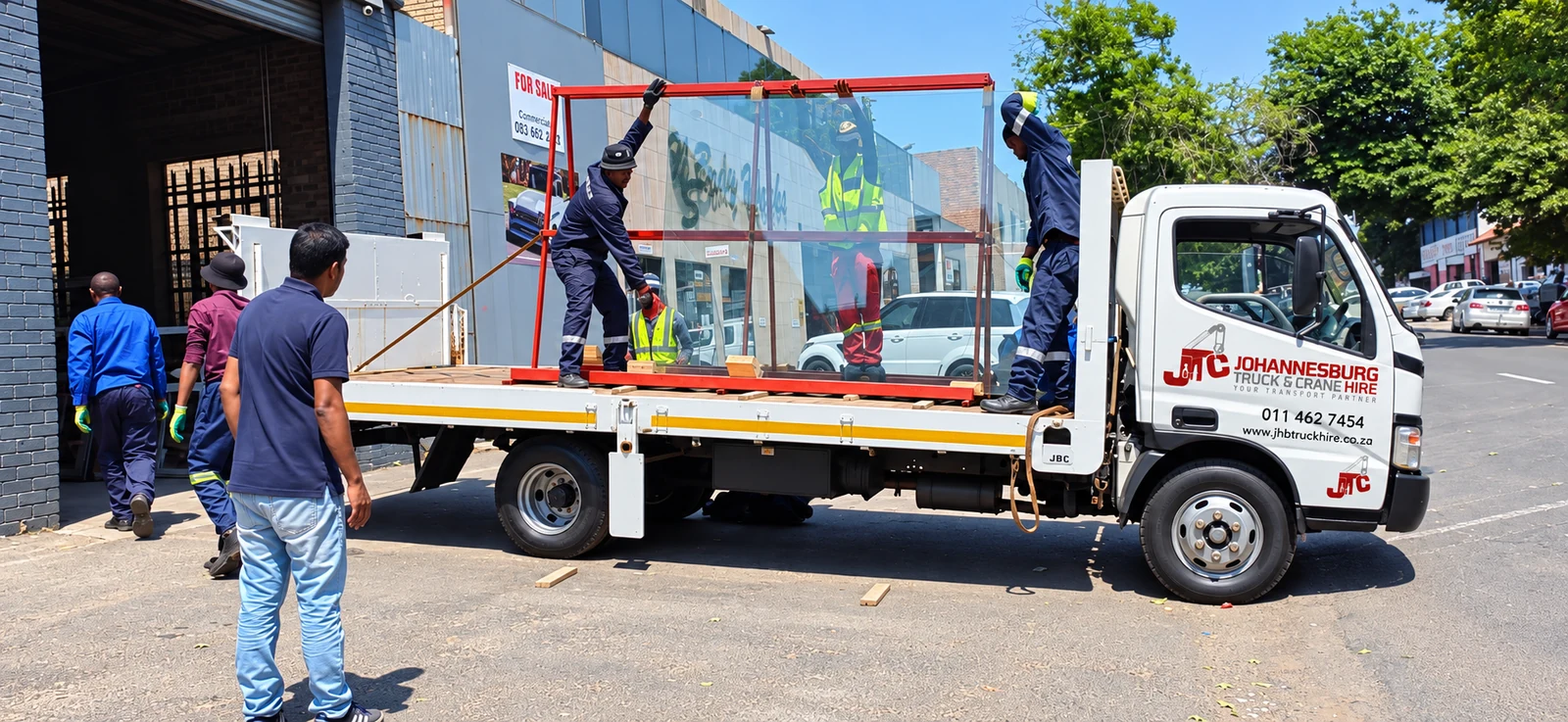 Enhanced JTC small flatbed truck transporting glass panels