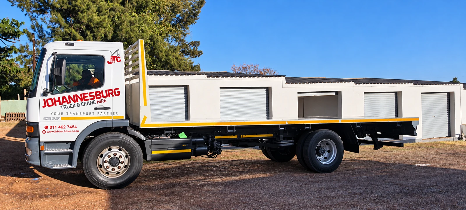Enhanced JTC-branded flatbed truck parked at the fleet yard