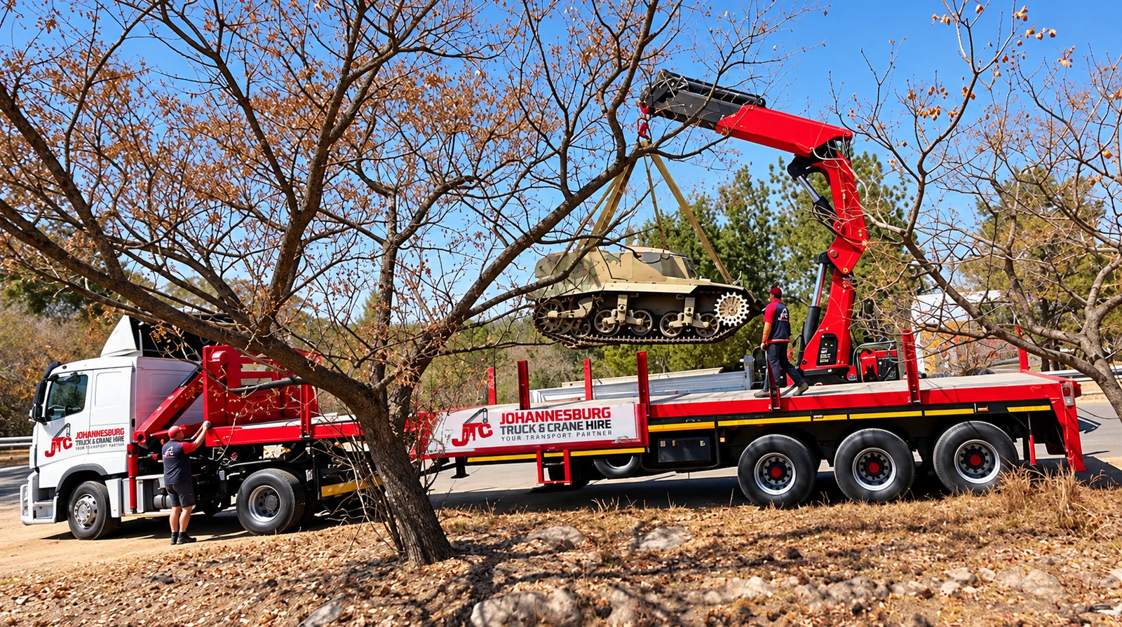 Enhanced JTC crane truck lifting a load beside trees