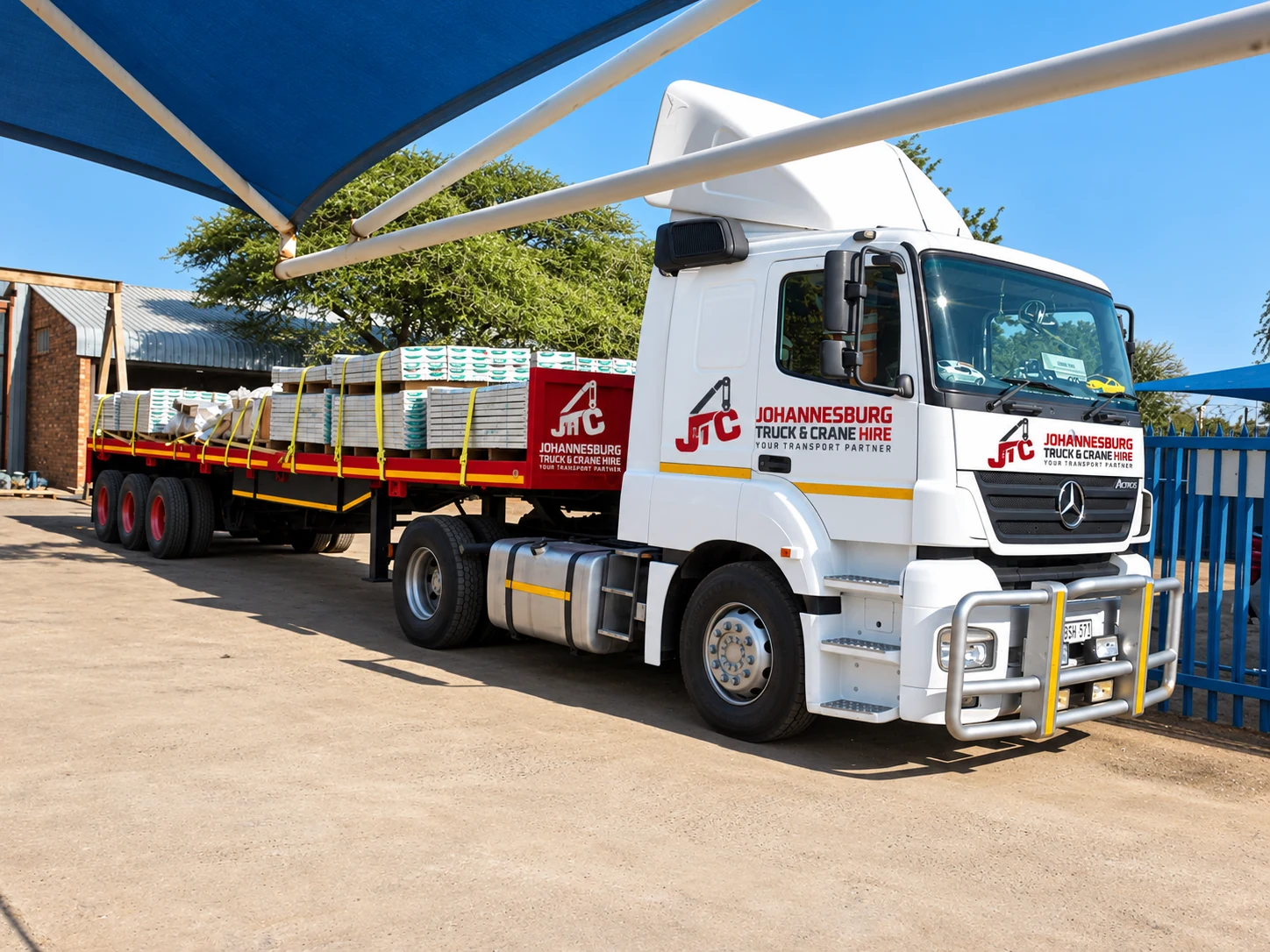 Enhanced JTC flatbed truck carrying an industrial load