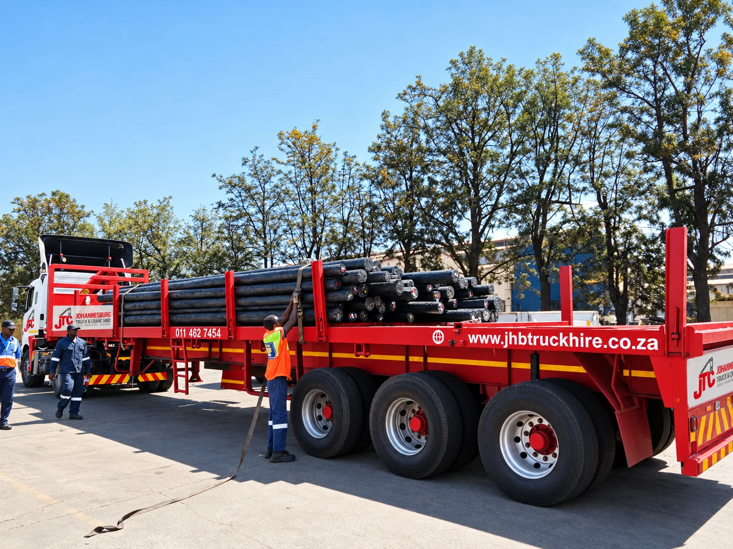 Enhanced JTC branded red trailer carrying timber poles
