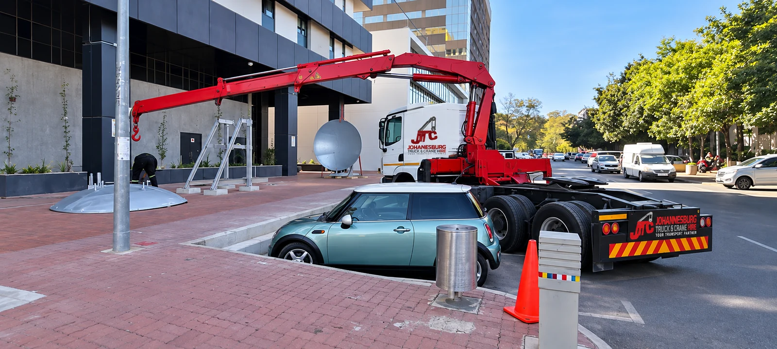 Enhanced JTC crane truck positioning equipment beside a building