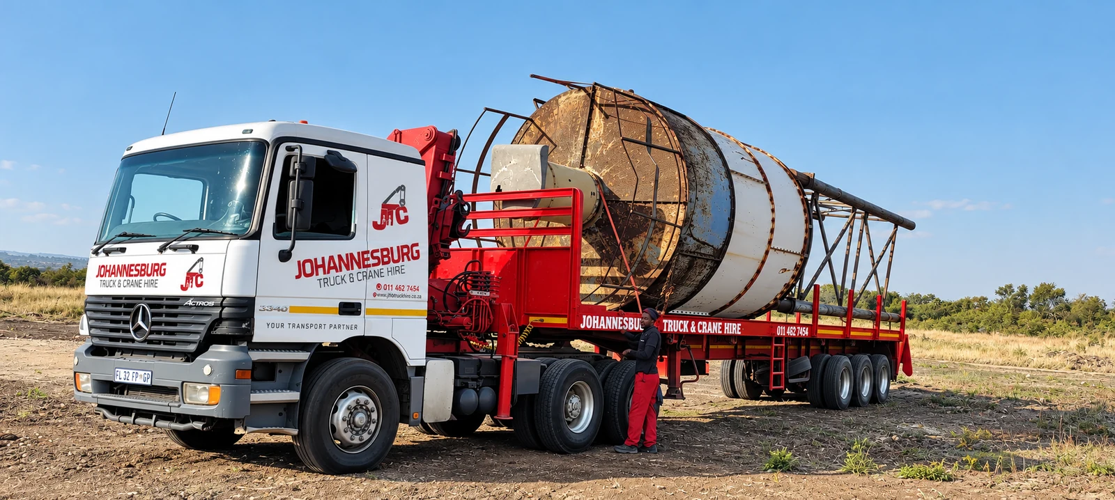 Enhanced JTC branded crane truck transporting a large cable drum
