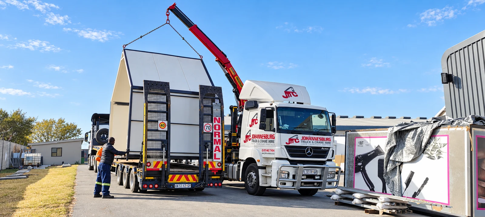 Enhanced JTC truck-mounted crane handling a modular building
